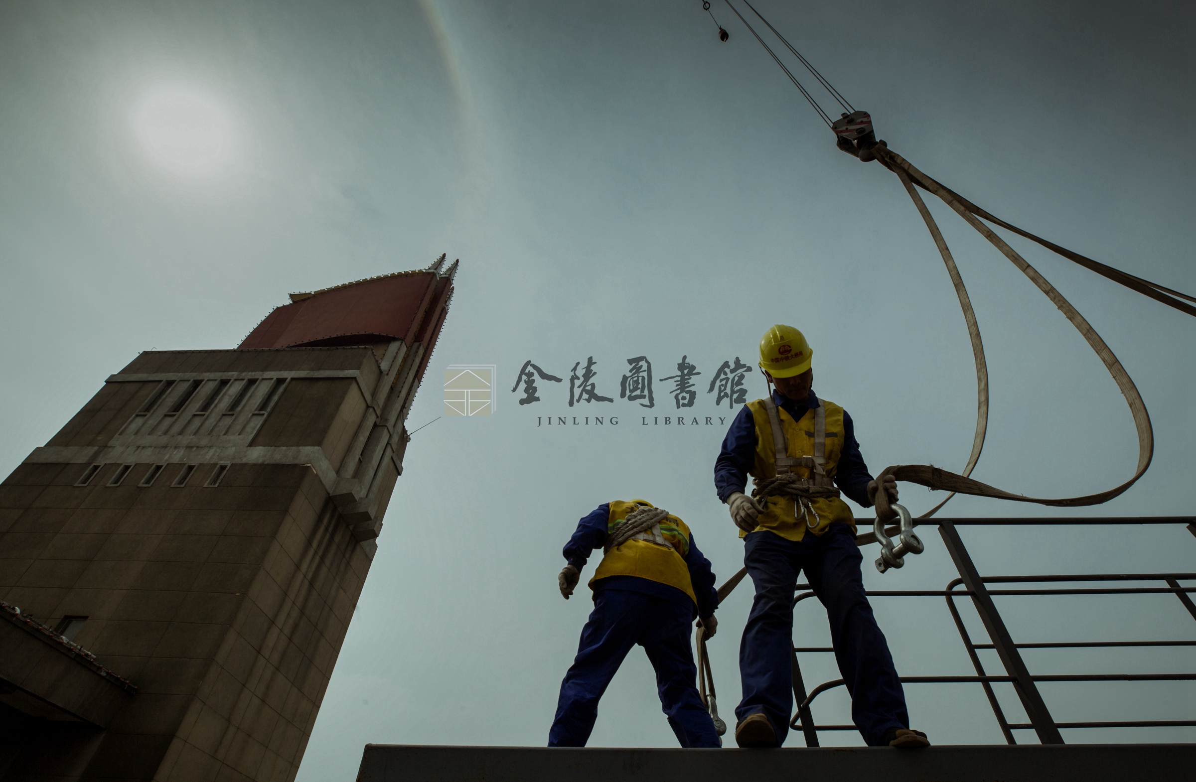 2017年4月5日，引桥下的工人将电缆通过狭小的检修通道口传递给路面工人。薛晓红摄